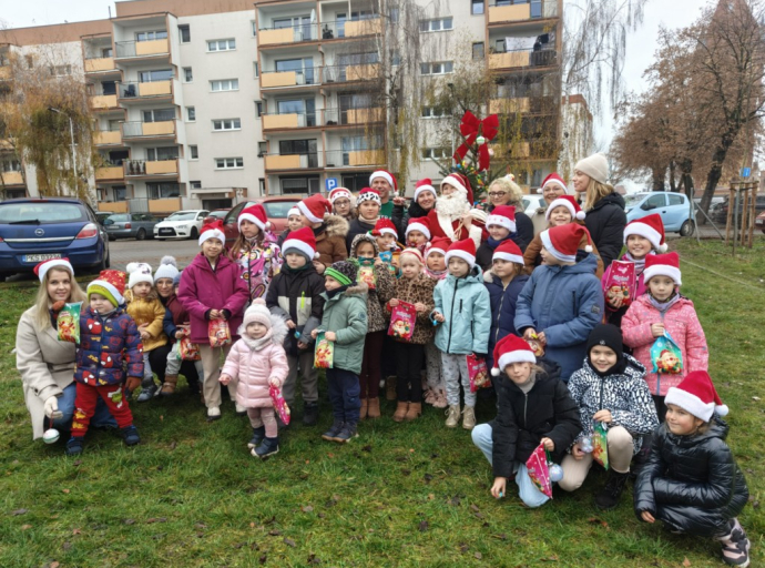 Uśmiechnięte dzieci pozują z Mikołajem podczas osiedlowych Mikołajek w Kościanie.